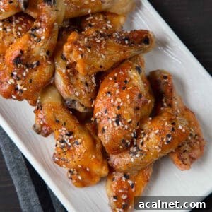 sweet and spicy baked wings on a rectangular white serving platter.