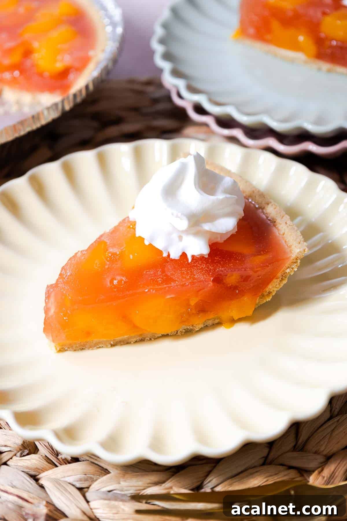 A slice of peach Jello pie topped with whipped topping.