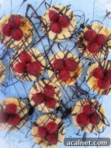 MINI CHOCOALTE TOPPED RASPBERRY CHEECAKES ON A SERVING PLATE