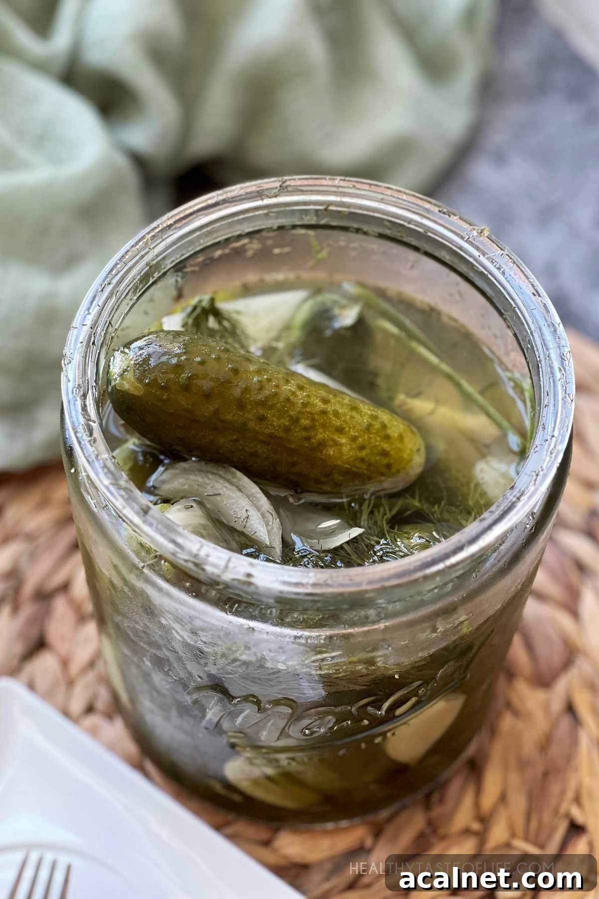 Lacto fermented cucumbers pickled in salt brine without vinegar packed in a large jar.