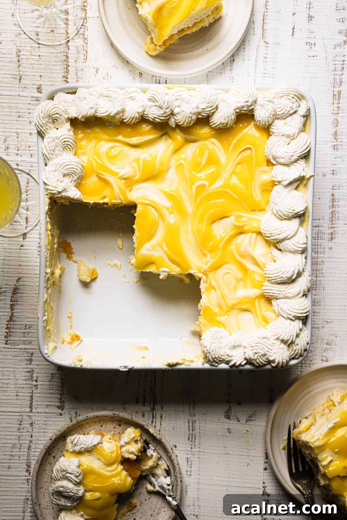 Limoncello Tiramisu Recipe: A Refreshing Citrus Twist on Tiramisu 2 Slice Limoncello tiramisu with plates and drinks around.