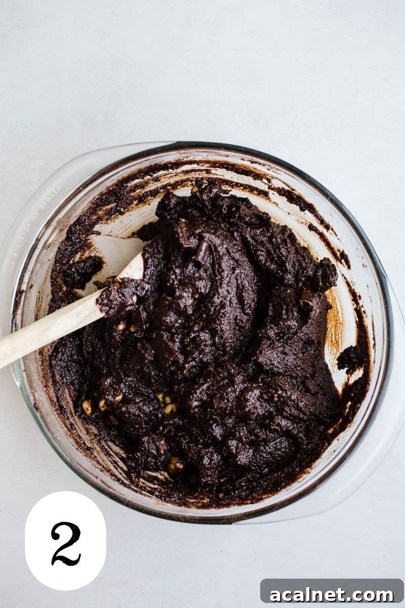 Chocolate batter with nuts in a glass mixing bowl.