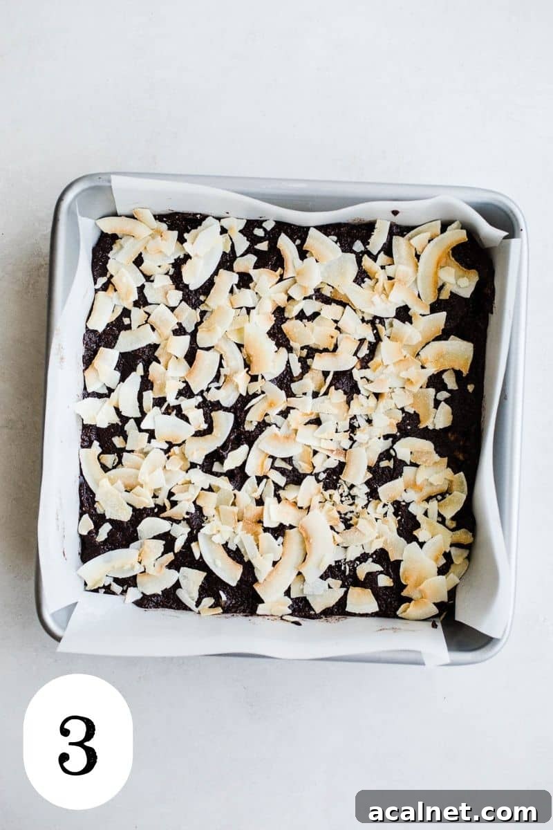 Unbaked coconut brownies in a baking pan.