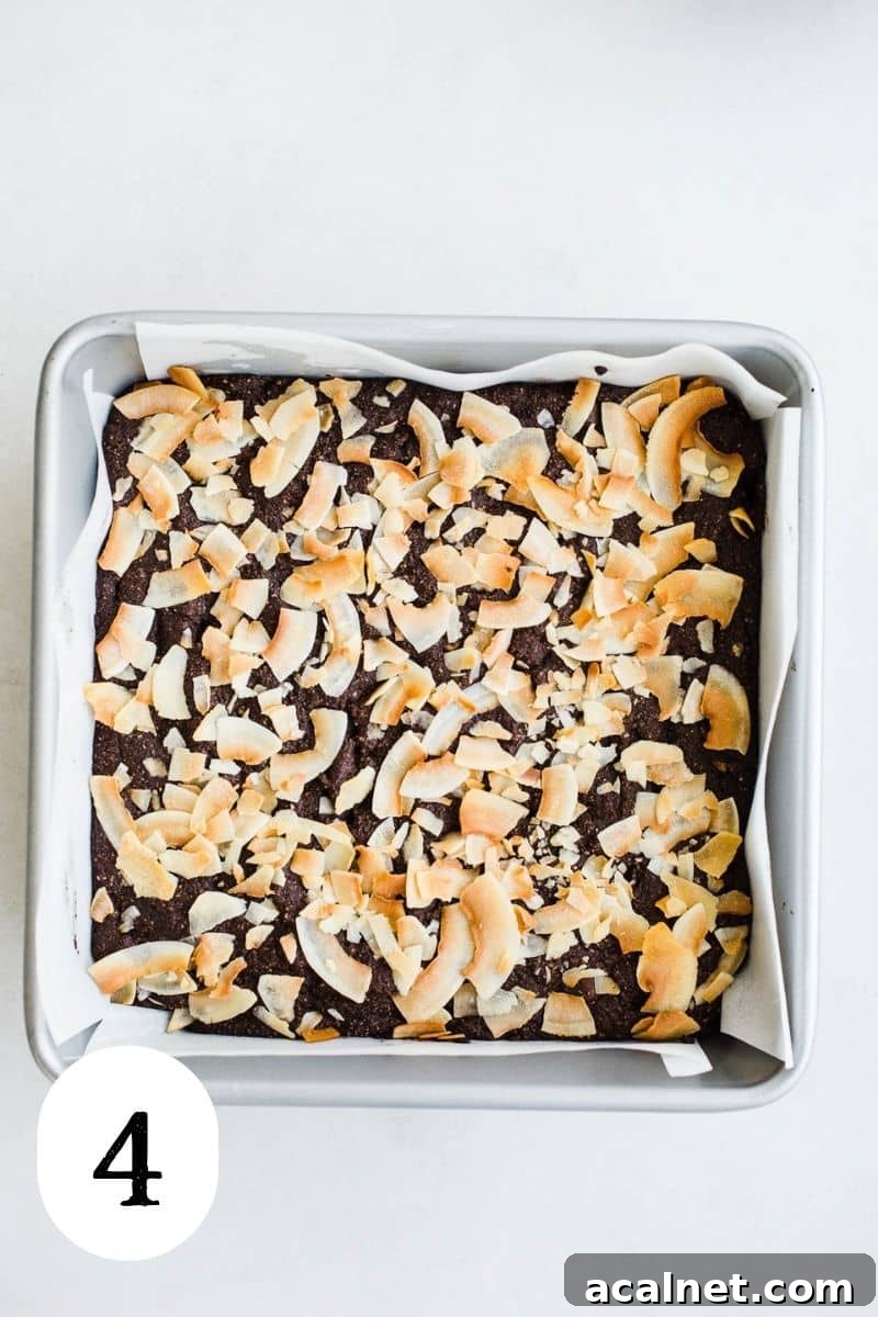 Baked brownies with coconut in a square pan.