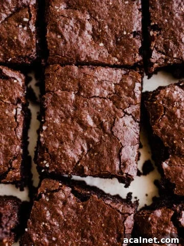 Freshly cut chocolate brownies on white parchment paper.