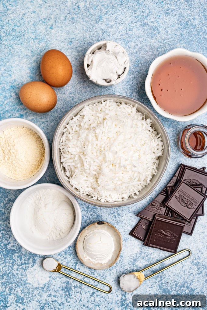 Ingredients portioned out into bowls: shredded coconut, eggs, dark chocolate, honey, flour, and coconut cream.