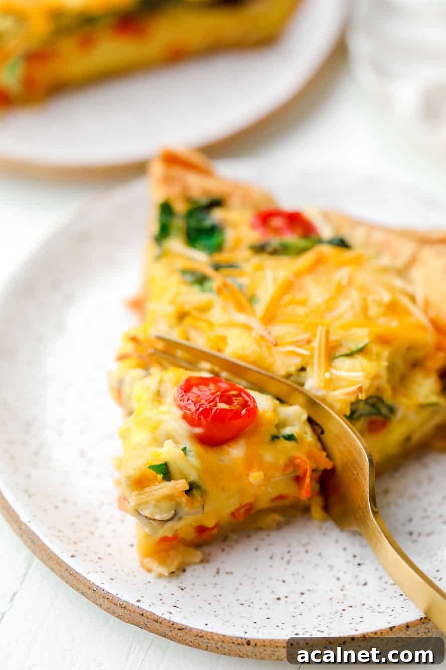 Vegan Just Egg Quiche Recipe: Flaky Crust & Creamy Filling 5 A fork taking a bite out of a slice of JUST Egg quiche.