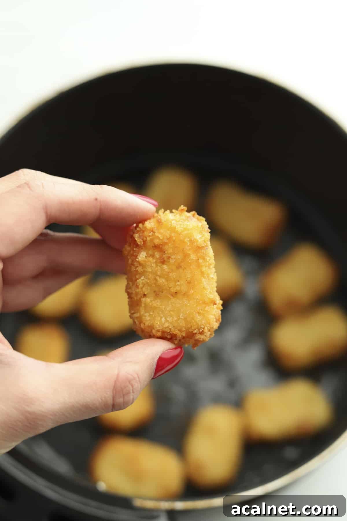 Crispy Air Fryer Potato Nuggets Recipe 7 hand holding air fryer nugget