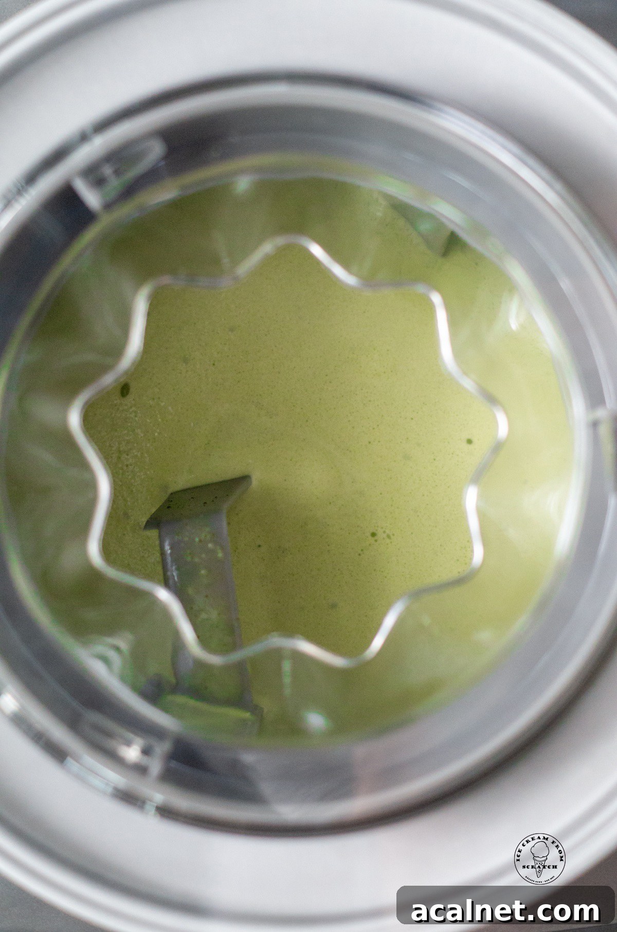 A photo of matcha ice cream churning in an ice cream maker, viewed from above