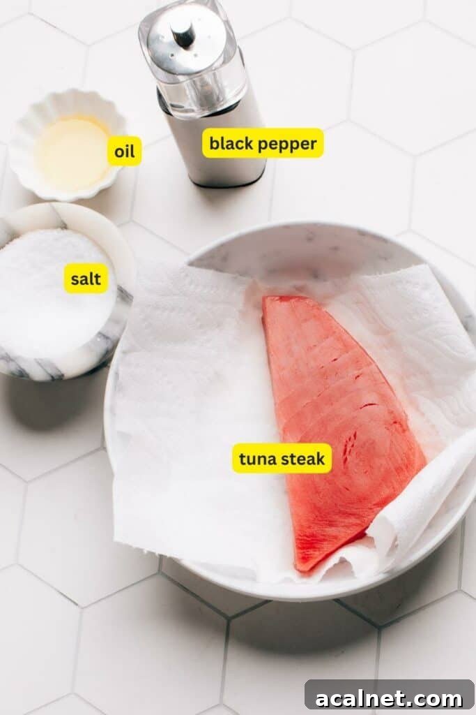 Ingredients for Air Fryer Tuna Steak arranged on a kitchen countertop, including tuna steak, salt, black pepper, and oil.