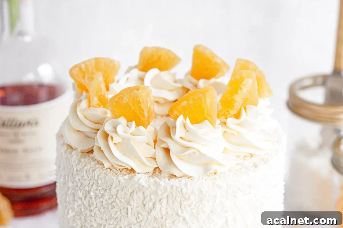 A close up of a cake top covered in shredded coconut and white frosting swirls with dried pineapples on top of each swirl.