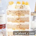 The inside of a pina colada cake with white frosting between each cake layer and pineapple filling.