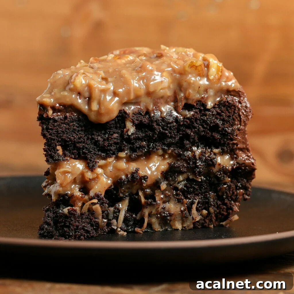 A slice of rich chocolate cake with layers of gooey caramel, classic German Chocolate Cake Frosting, and pecan topping, served on a dark plate against a wooden background.