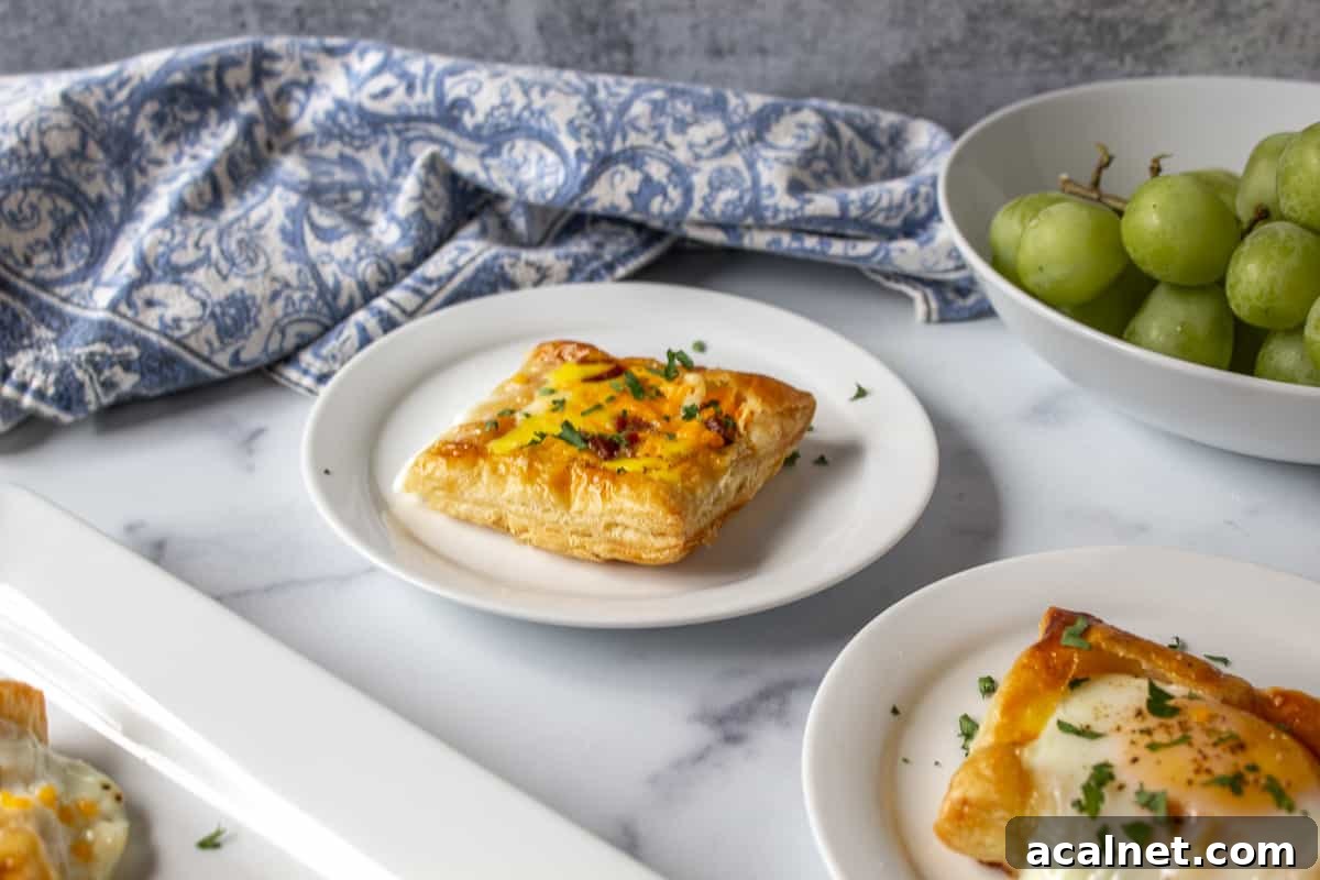 Baked eggs in puff pastry on a white plate.