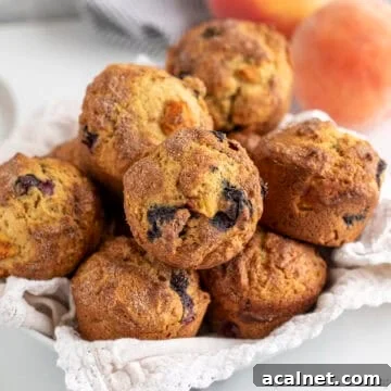A basket filled with blueberry peach muffins.