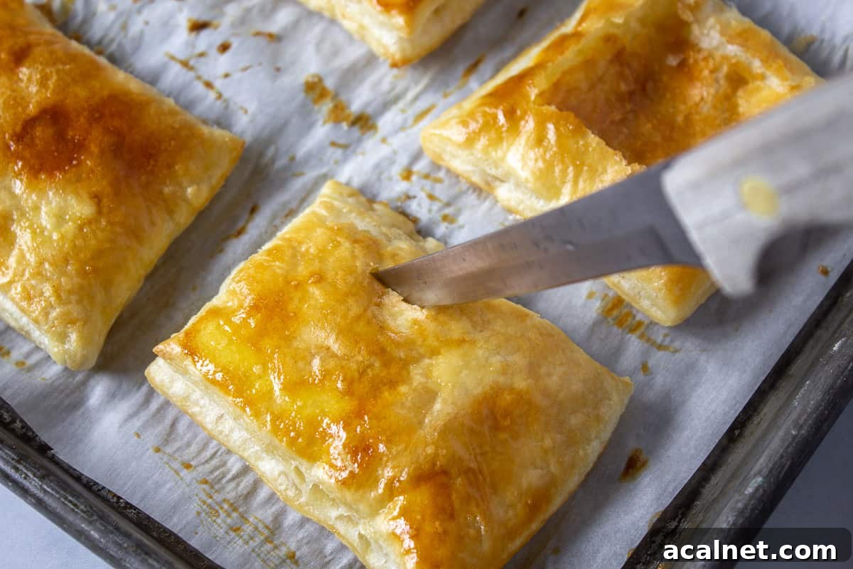 A knife slicing into a cooked pastry.