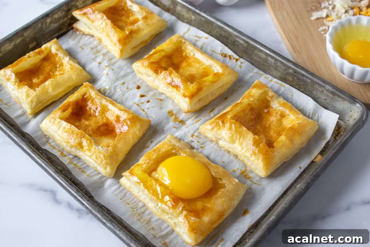 Puff pastry shells with a raw egg in one of the shells.