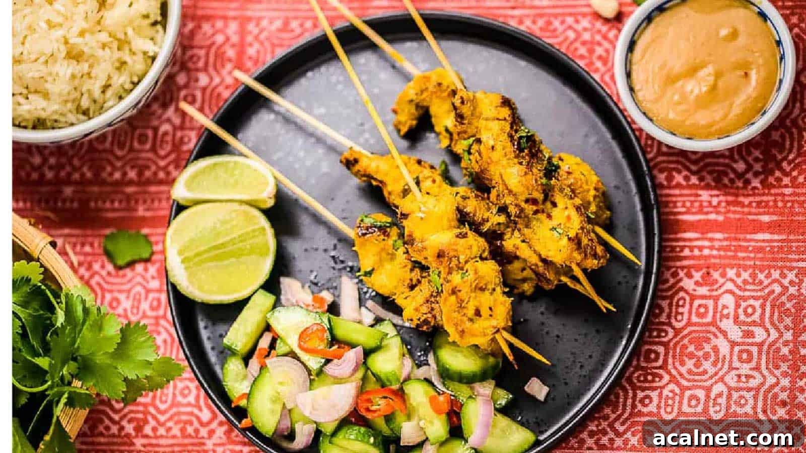 29 Chicken Dinners That Keep Coming Back to Our Weekly Menu 12 Overhead shot of thai chicken satay on a black plate with peanut sauce on the side.