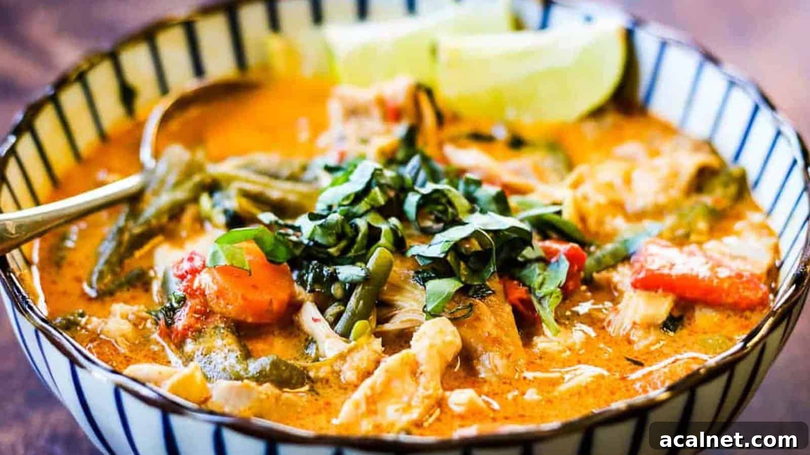 29 Chicken Dinners That Keep Coming Back to Our Weekly Menu 13 Low angle shot of a blue and white striped bowl filled with Thai chicken curry.