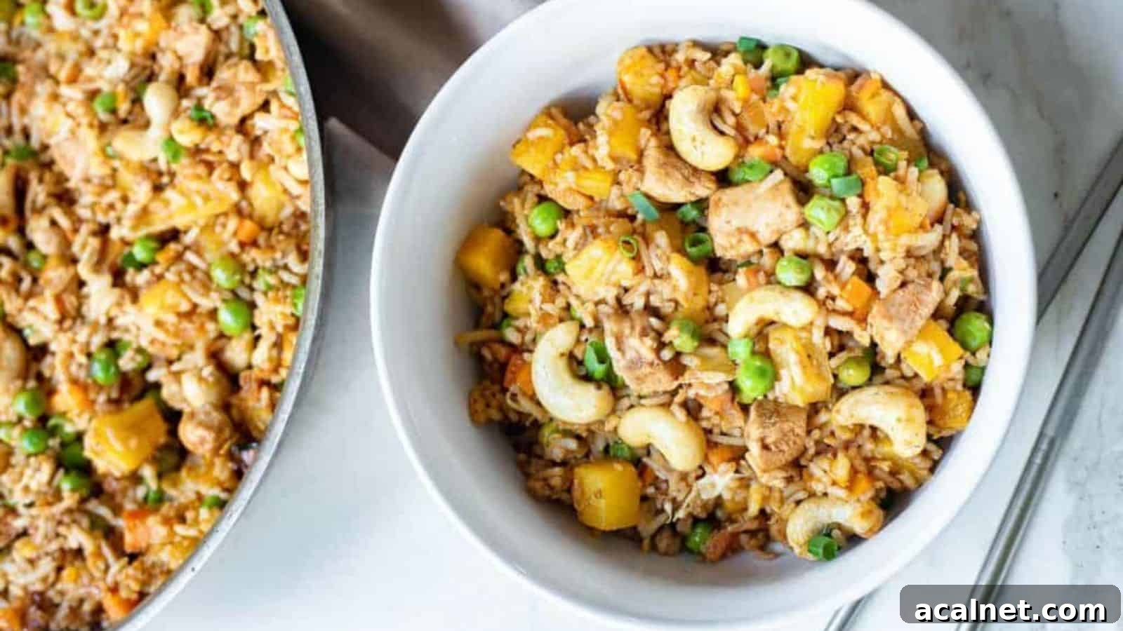 29 Chicken Dinners That Keep Coming Back to Our Weekly Menu 15 Overhead shot of Thai fried rice in a white bowl with a skillet of fried rice on the side.