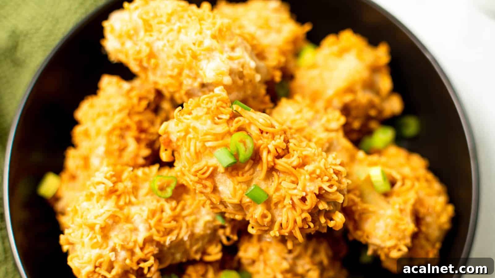 29 Chicken Dinners That Keep Coming Back to Our Weekly Menu 7 Hand reaching into a bowl of ramen fried chicken pieces.