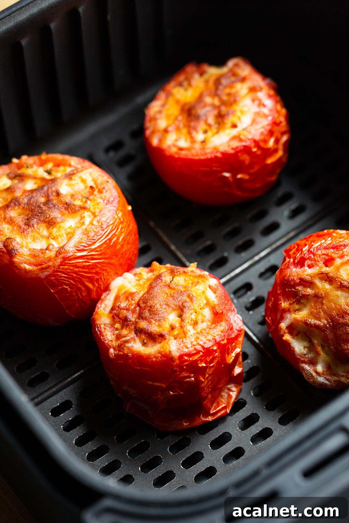 Air fryer tomatoes in air fryer basket.