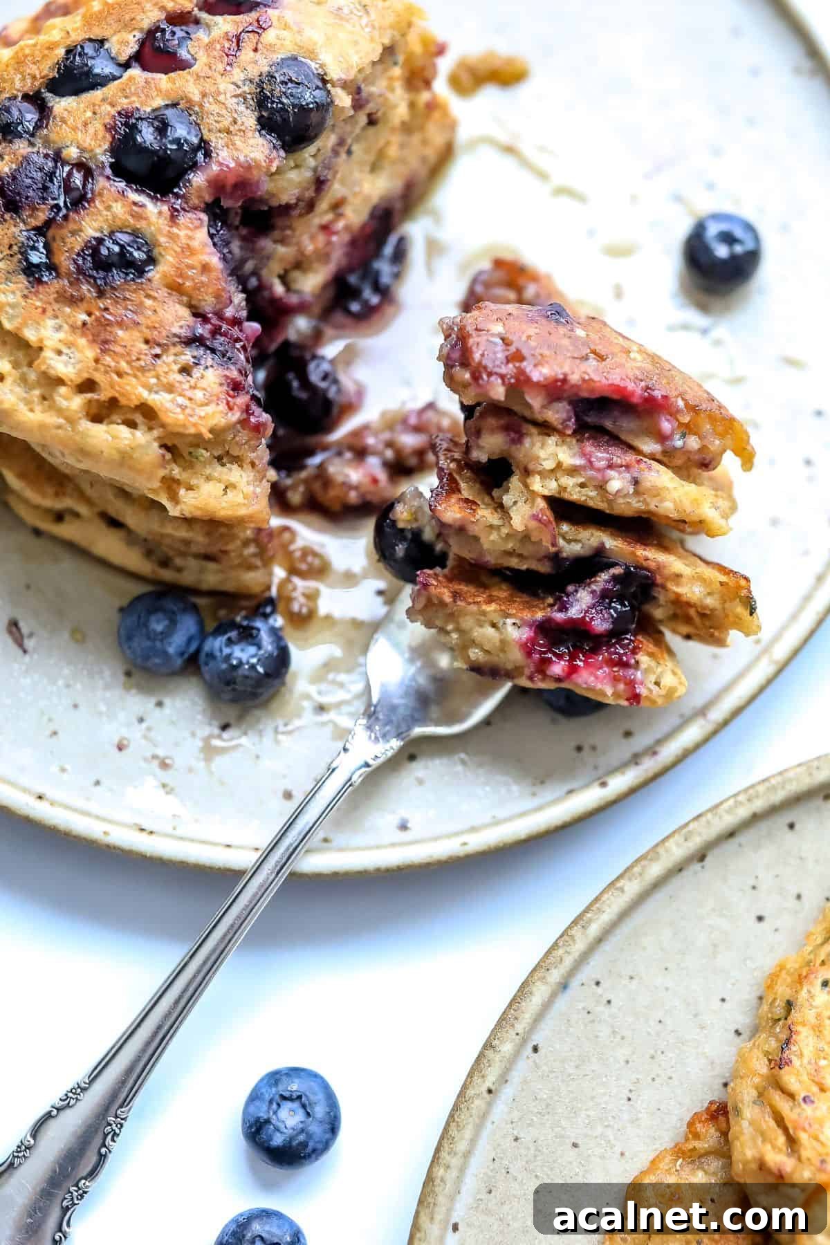 healthy whole wheat pancakes with berries and a silver fork.