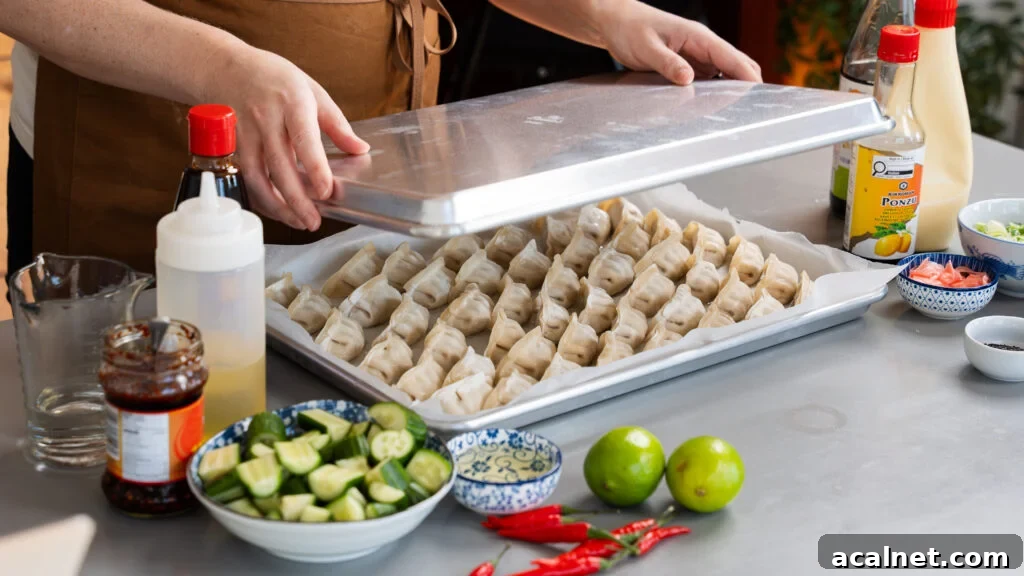 Covering a sheet pan full of dumplings with another sheet pan for steaming.