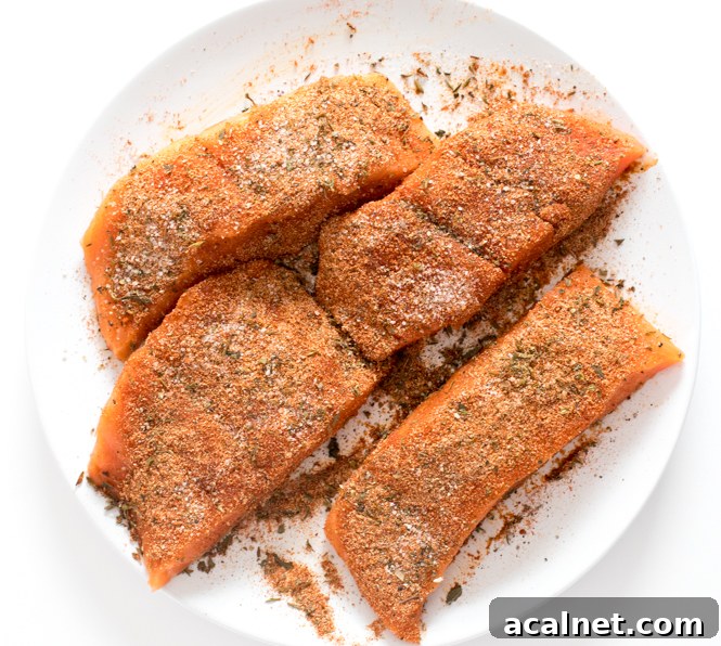 Blackened Salmon Recipe: Bold Cajun Seasoned Pan-Seared Fillet 3 sprinkling fish with seasonings on white plate