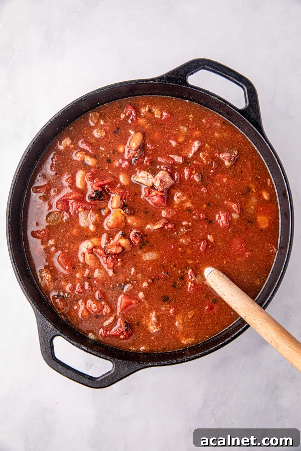 Stirring Smoked Brisket Chili ingredients in cooking pot