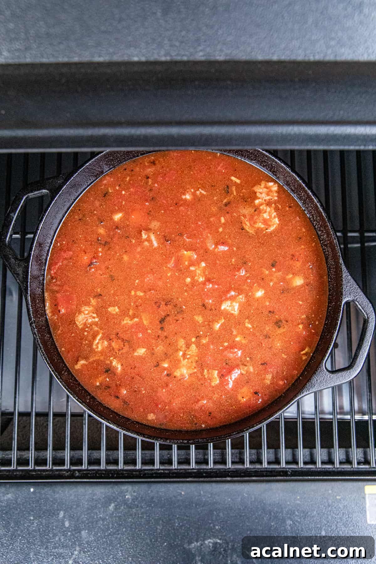 Placing the dutch oven full of Smoked Brisket Chili in the smoker