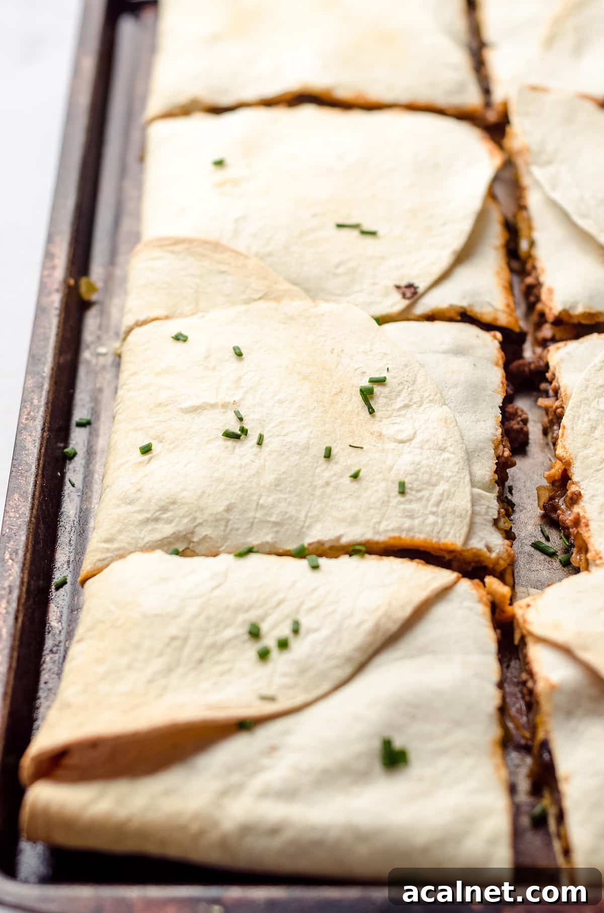 Sheet Pan Quesadillas: Quick Oven-Baked Mexican Dinner 15 Quesadillas that have been baked on a sheet pan and cut into squares.