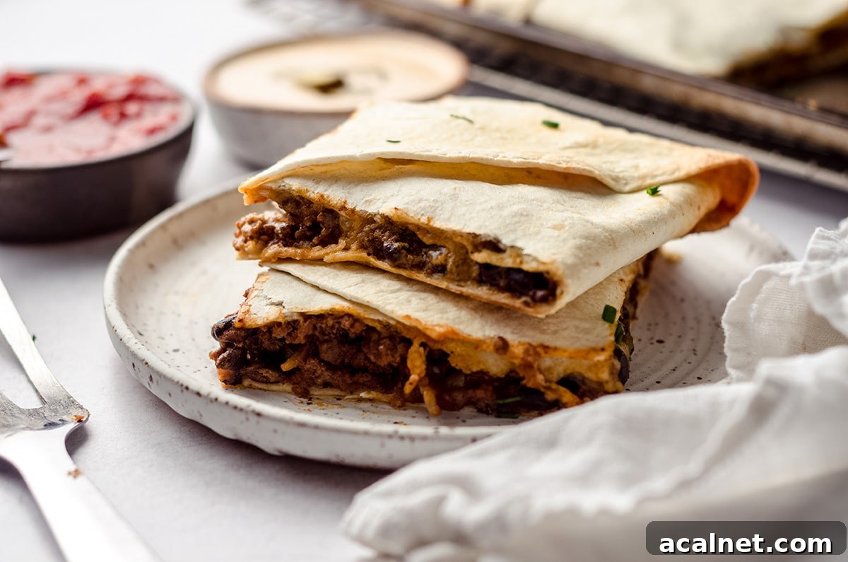 Sheet Pan Quesadillas: Quick Oven-Baked Mexican Dinner 18 A stack of two square quesadillas on a plate.