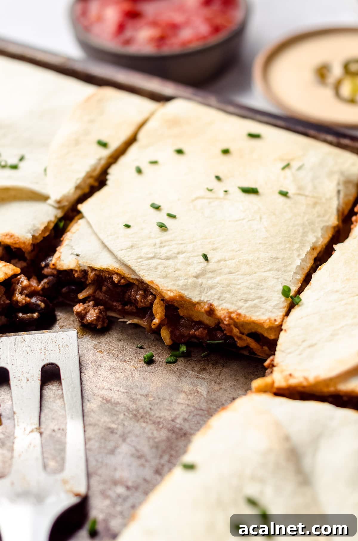 Sheet Pan Quesadillas: Quick Oven-Baked Mexican Dinner 3 A close up of sheet pan quesadillas filled with ground beef and cheese.