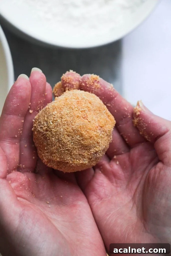 Gochujang Cheesy Risotto with Creamy Korean Chili Flavor 14 Close up of coated arancini ball in hands.