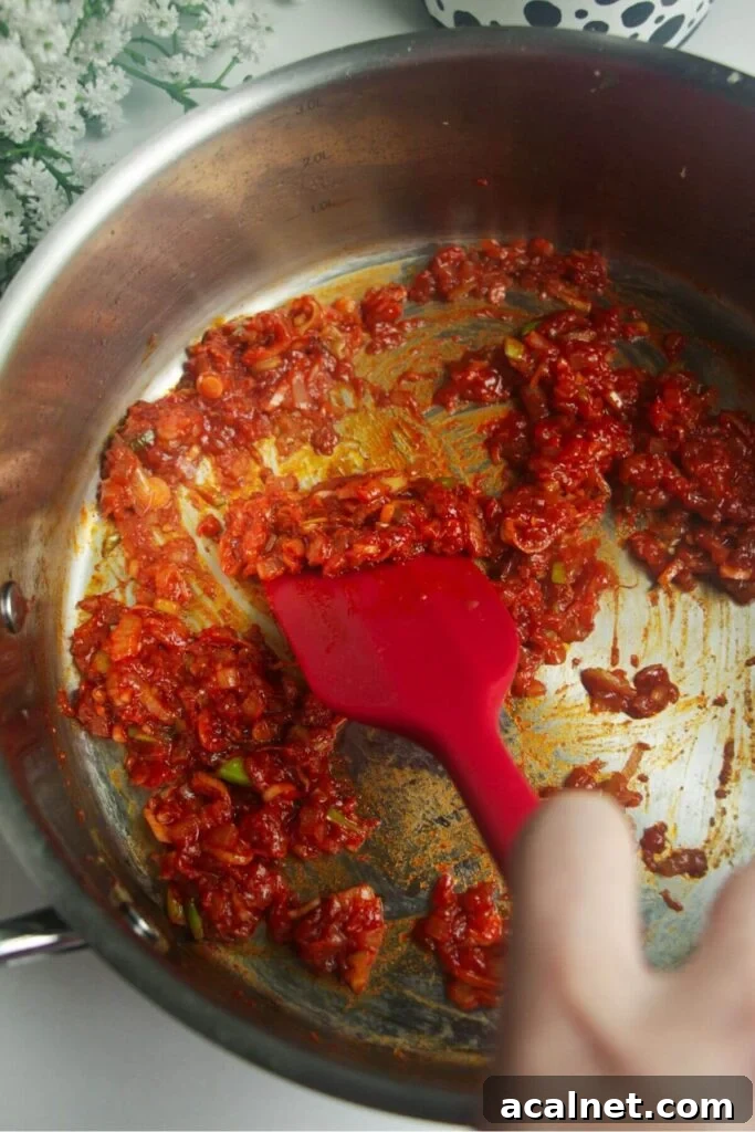 Gochujang Cheesy Risotto with Creamy Korean Chili Flavor 6 Gochujang paste cooking in a large pan.