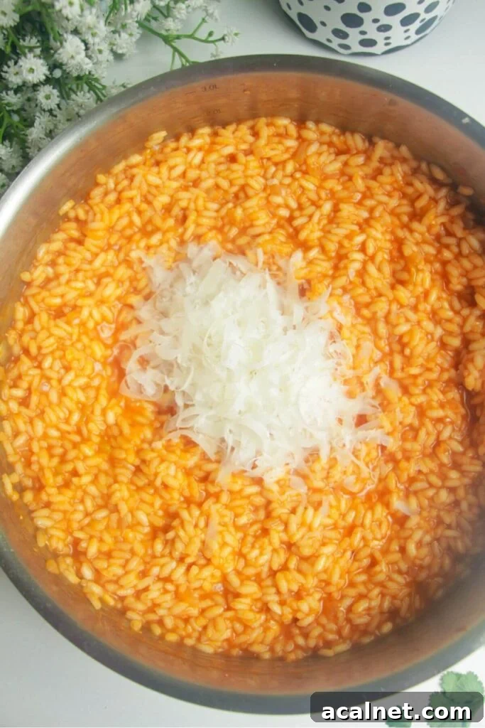 Gochujang Cheesy Risotto with Creamy Korean Chili Flavor 9 Grated parmesan on top of cooked gochujang risotto in a pan.