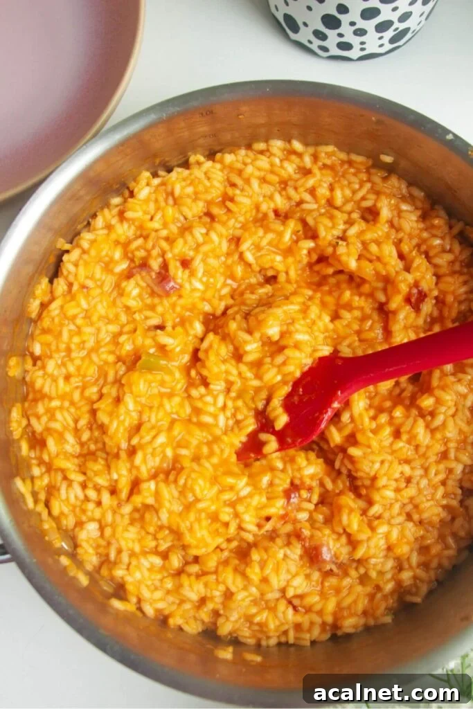 Gochujang Cheesy Risotto with Creamy Korean Chili Flavor 10 Gochujang risotto stirred with a spatula in a large pan.