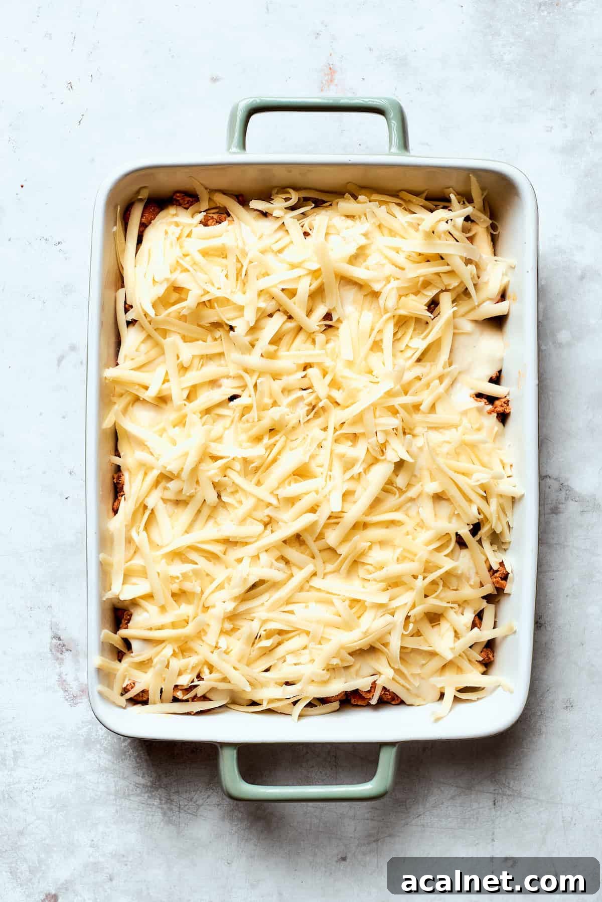 Layer on cheese Cheese is added to biscuits and gravy casserole.