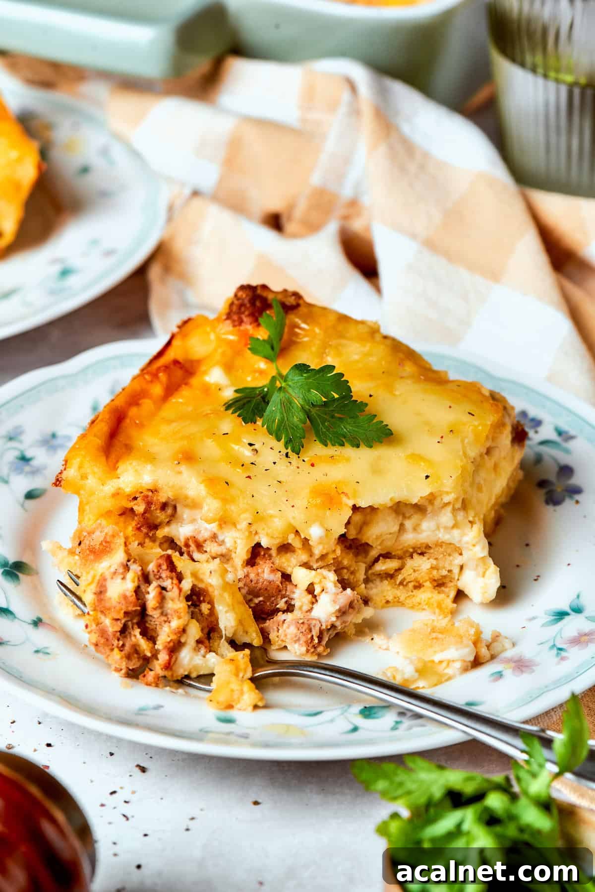 A fork cuts into a piece of biscuits and gravy casserole A fork cuts into a piece of biscuits and gravy casserole.