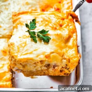 Cheesy Biscuits and Sausage Gravy Casserole Recipe 2 Scooping out a slice of casserole from the baking dish.