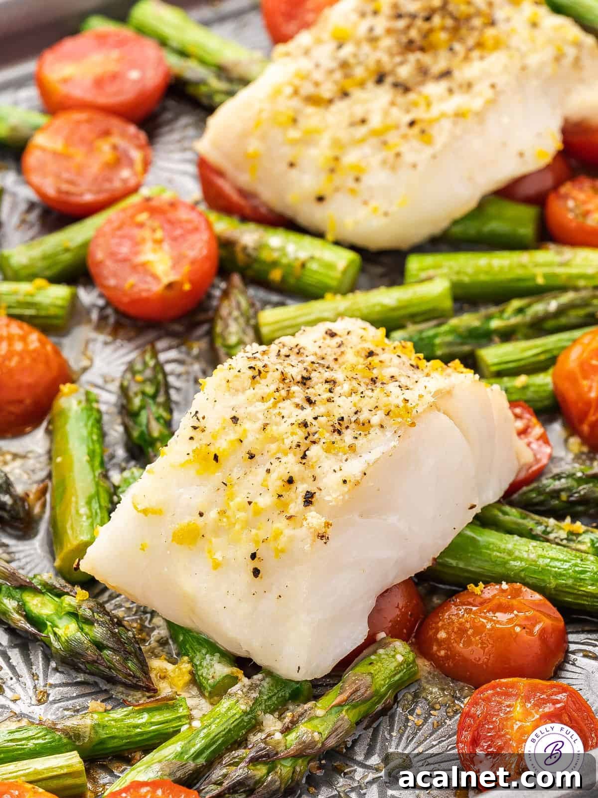 baked cod over roasted tomatoes and asparagus on sheet pan