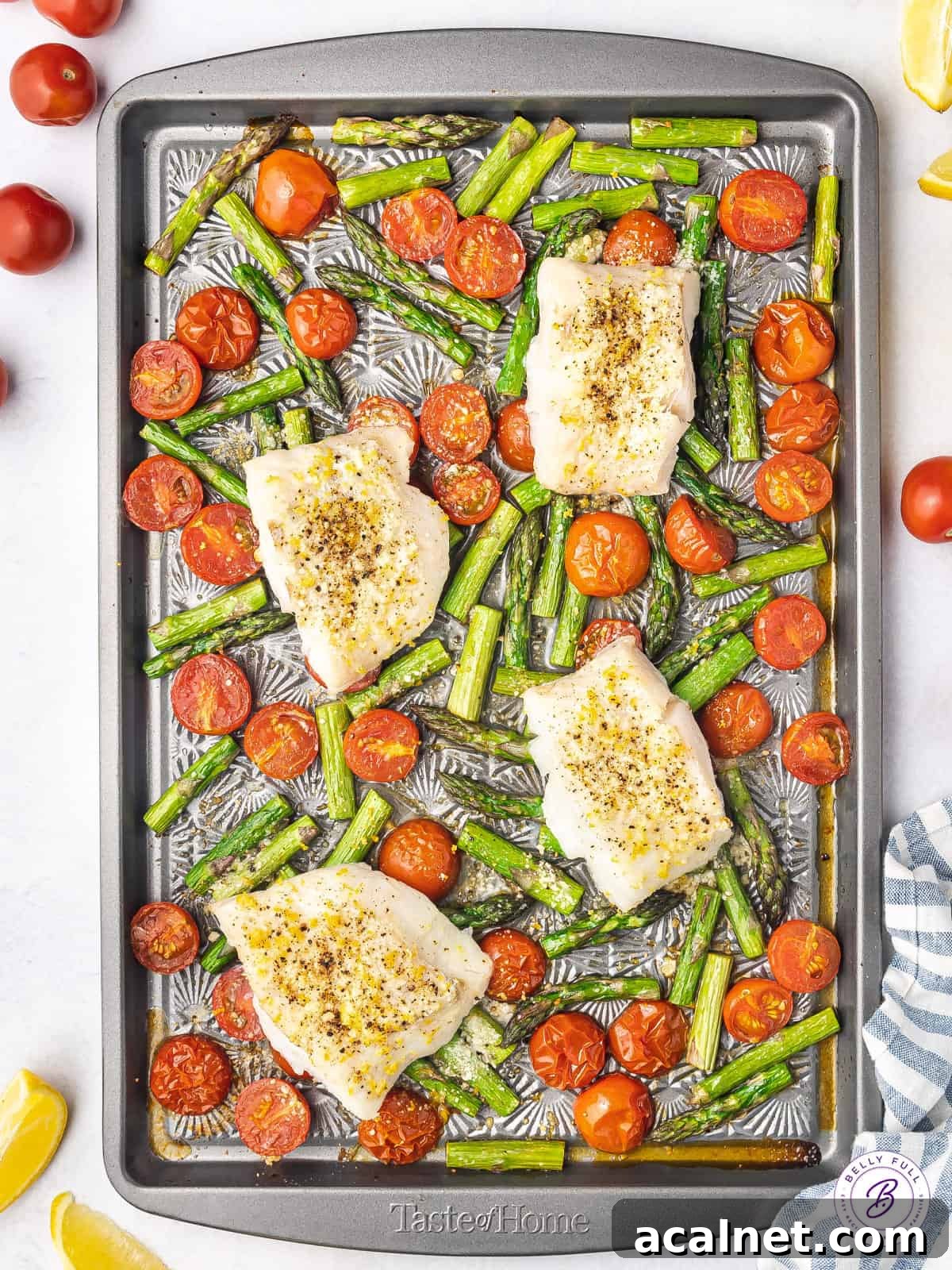 sheet pan of baked white fish over roasted tomatoes and asparagus