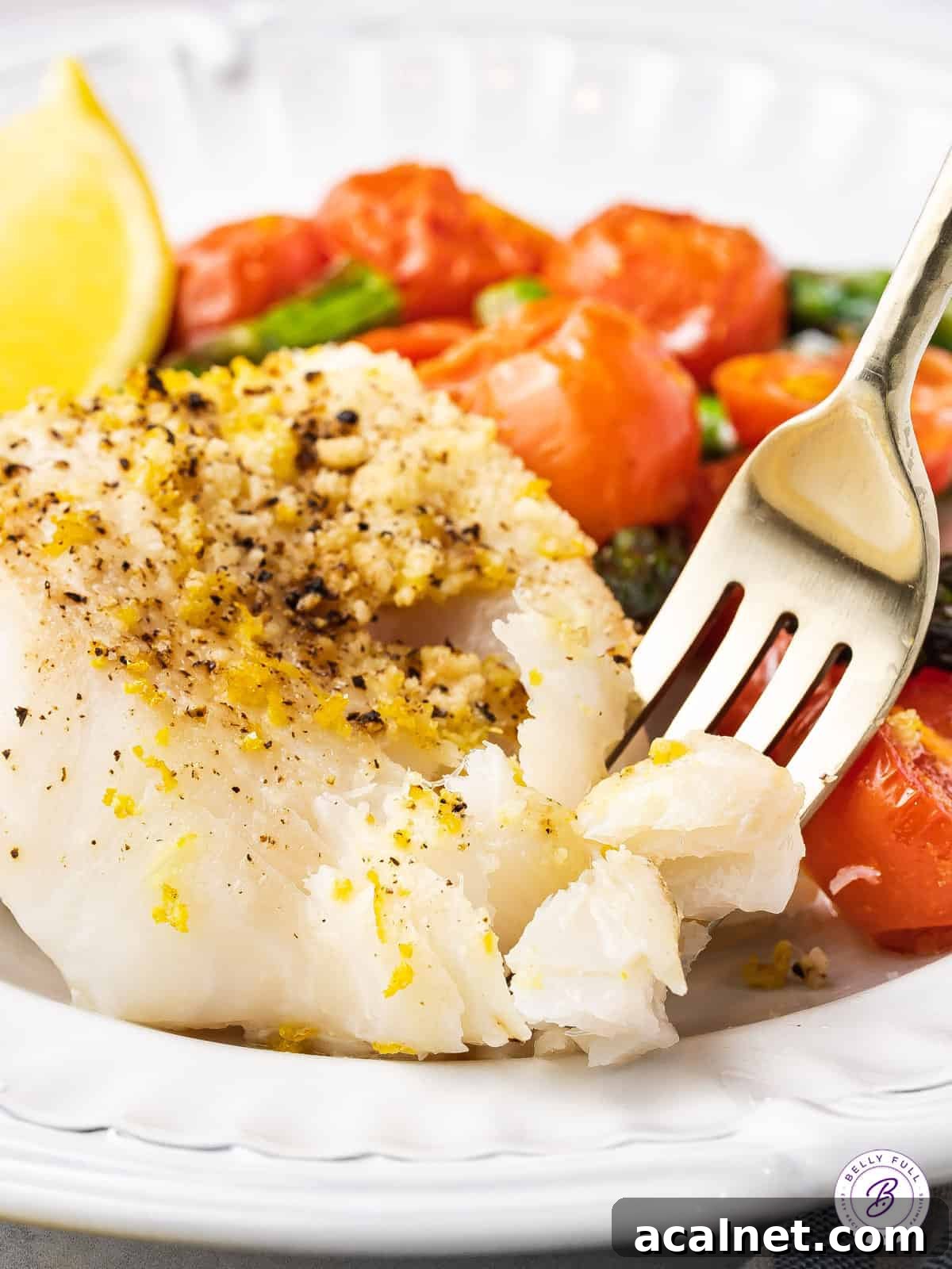 fork separating flakey baked white fish