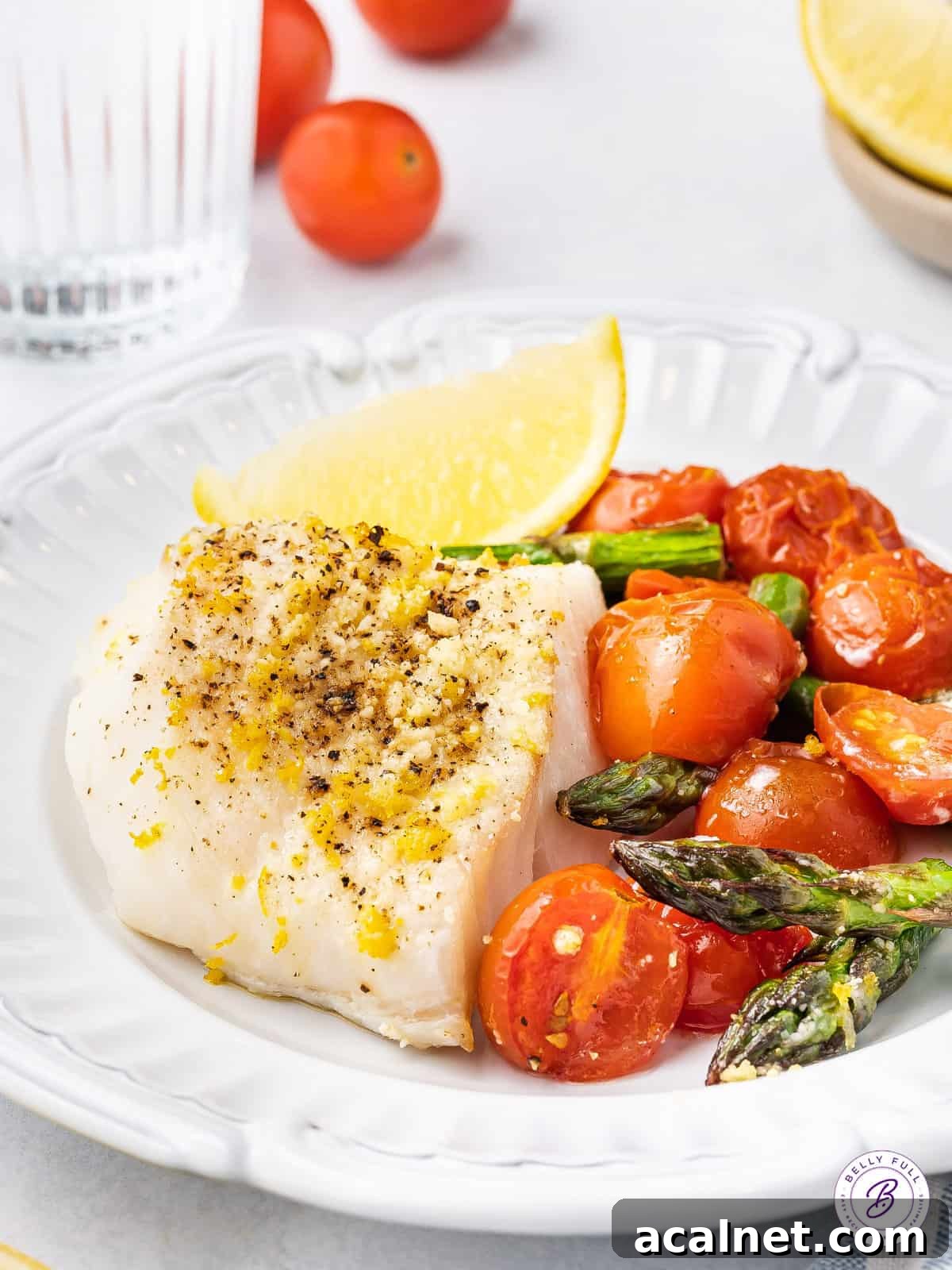 baked cod on plate with roasted tomatoes and asparagus