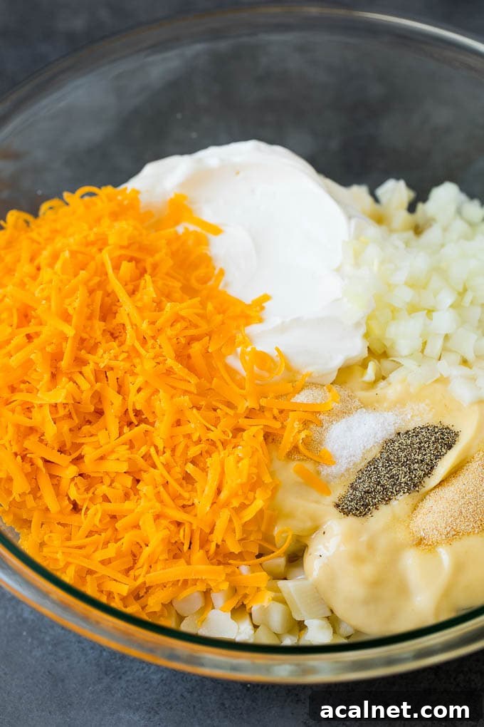 Diced potatoes, cream soup, shredded cheese and spices in a bowl.