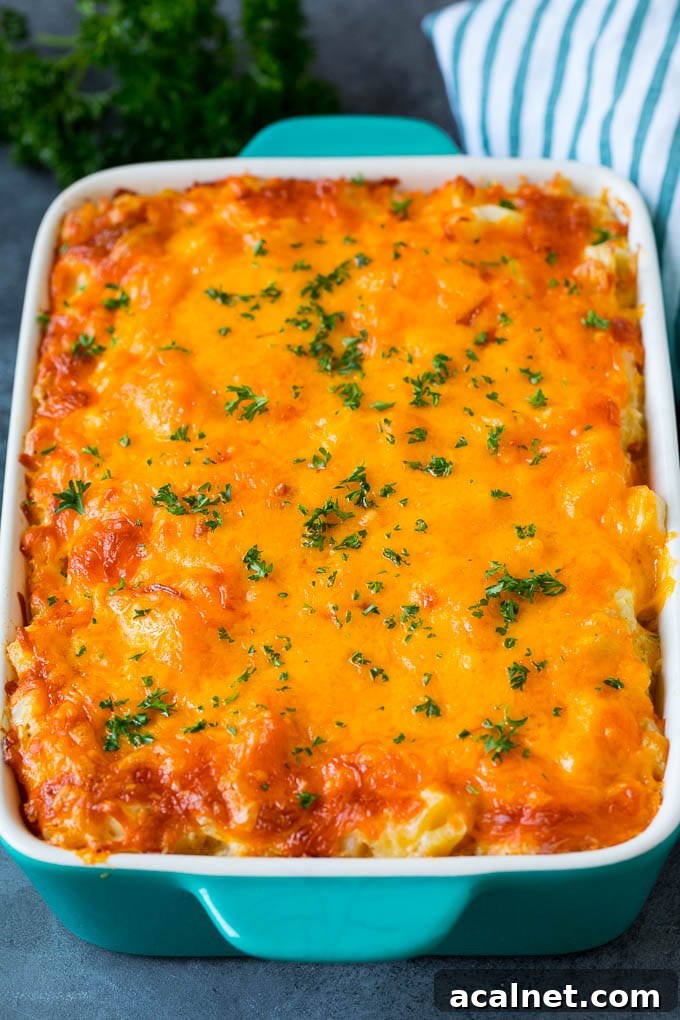 Cheesy potatoes in a casserole dish topped with melted cheddar and parsley.