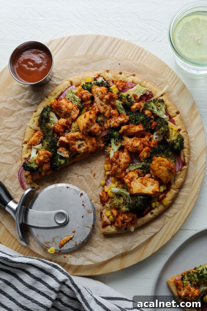 BBQ Tofu Pizza on serving board with pizza cutter by Flora & Vino