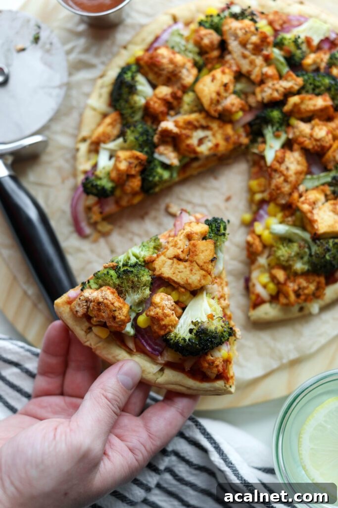 BBQ Tofu Pizza in hand by Flora & Vino
