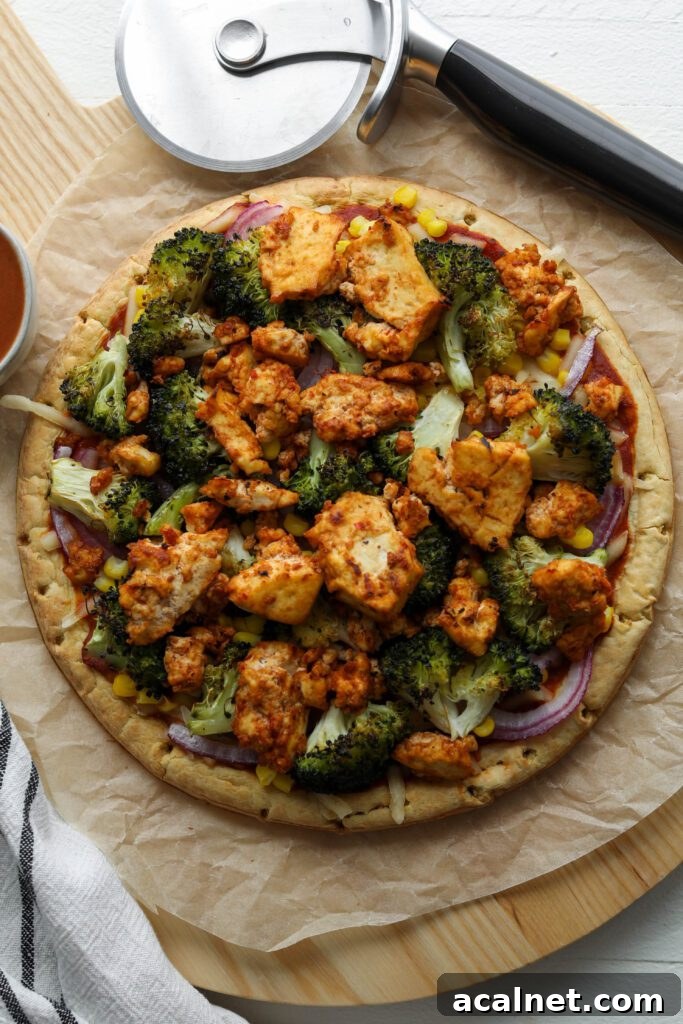 Tofu BBQ Pizza on cutting board with pizza cutter on wooden board by Flora & Vino